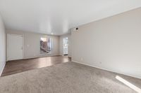 Living area with wooded entrance and carpet and view of stairs