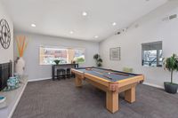 Games room with pool table, seating, plants, and windows