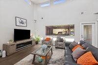 Community area with seating, TV, high ceilings and windows