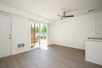 Open living space with wooden floor and ceiling fan and patio.
