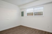 Bedroom with wooden floor and window and circuit breaker.