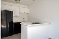 Kitchen with counters, sink, fridge, and oven.