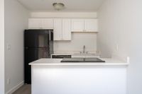 Kitchen with fridge, sink, counter, and oven.