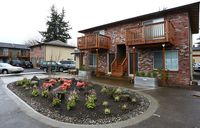Apartment with parking lot and flowers and plants.