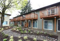 Apartment with parking lot and flowers and plants.
