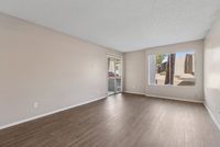 Solaris at Shadow Mountain living room with vinyl plank flooring and sliding glass door to a patio.