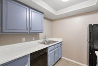 Modern kitchen featuring blue cabinets, white countertops, and a double stainless steel sink.