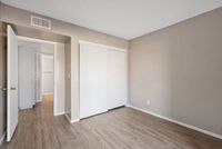 Bedroom featuring neutral walls, wood-style flooring, and a large sliding door closet.