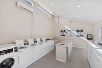On-site laundry care center with multiple white washers and dryers for resident use.