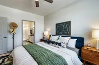 Modern bedroom with stylish decor and an ensuite bathroom, featuring a plush bed and accent lighting.