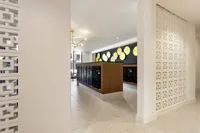 Modern apartment lobby with stylish decor, golden wall accents, and sleek mailboxes.