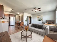 Bright open-concept apartment with stylish furnishings, featuring a modern kitchen, cozy living area, and elegant bedroom corner.