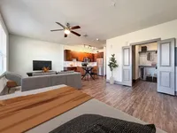 Modern open-concept apartment featuring a cozy living area, stylish kitchen with stainless steel appliances, and spacious closet space.