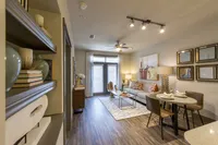 Elegant living room with cozy seating, stylish decor, and abundant natural light from large windows, perfect for relaxing and entertaining.