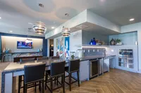 Luxurious open-concept kitchen and living area with modern decor, elegant lighting, and steel appliances.