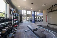 Bright and modern fitness center with state-of-the-art equipment, including free weights, exercise machines, and yoga balls.