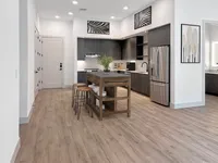 East Austin Apartments | Apartments in Austin | New apartments in Austin |Modern kitchen with elegant wood flooring, featuring sleek dark cabinetry, stainless steel appliances, and a rustic island with bar seating.