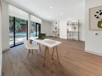 East Austin Apartments | Apartments in Austin | New apartments in Austin |Bright, modern home office with sleek white desk, stylish shelving, and floor-to-ceiling windows offering a serene view.