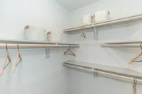 Spacious walk-in closet with sleek shelving and elegant baskets, perfect for stylish and organized living.