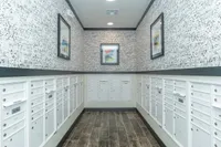 Bright mailroom with elegant patterned walls, secure mailboxes, and modern artwork creating a stylish ambiance.