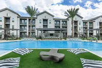 Luxurious apartment complex with stunning poolside oasis, modern architecture, and palm trees for a tropical retreat feel.