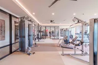 Modern fitness center with state-of-the-art gym equipment, sleek design, and large windows for natural light.