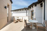Bright outdoor terrace with elegant seating, offering a stylish space for relaxation or dining.