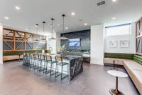 Contemporary open-concept lounge with a sleek marble kitchen island, modern bar seating, and stylish lighting.