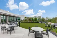 Modern rooftop terrace featuring stylish seating, lush greenery, and panoramic sky views, perfect for relaxation and gatherings.