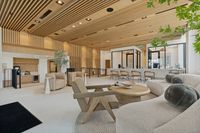 Luxurious modern lobby with sleek wooden accents, elegant neutral furniture, and abundant natural light creating a welcoming atmosphere.