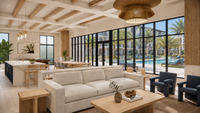 Luxurious open-concept living space with modern furnishings, expansive windows, and views of a tropical pool area.