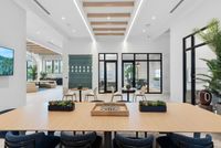 Elegant modern interior with chic wooden ceiling beams, abundant natural light, and stylish seating areas, perfect for gatherings and relaxation.