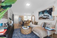 Contemporary living room with cozy sofa, stylish decor, and open-concept kitchen featuring modern amenities.