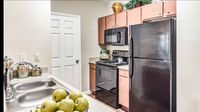 Apartment kitchen with black appliances and granite countertops at Bennett Baytown
