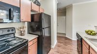 Open-concept apartment kitchen with breakfast bar at Bennett Baytown