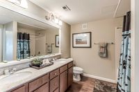 Apartment bathroom with large vanity and mirror at Bennett Baytown