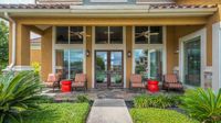 Apartment clubhouse entrance with covered patio and landscaping