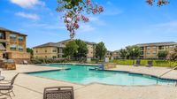 Community swimming pool with lounge chairs and landscaped surroundings