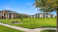 Landscaped community green space with walking paths, picnic tables, and barbecue areas