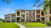 Exterior view of apartment building with balconies and landscaped lawn