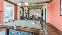 Clubhouse game room with pool table, dining tables, fireplace, and entertainment area