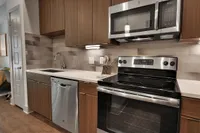 Kitchen with stainless range, microwave, dishwasher and tile backsplash