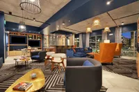 Clubhouse lounge with sofas, armchairs, TV and pendant lights