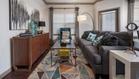 Chic living room with a cozy gray sofa, stylish accent pillows, elegant wooden sideboard, and modern art enhancing the warm, inviting ambiance.
