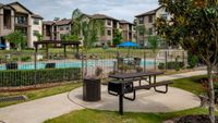 Charming apartment complex with lush landscaping and a sparkling pool, perfect for relaxing in style.