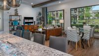 Chic and modern apartment living room featuring a cozy seating area, stylish wooden furniture, and a glass dining set with views of lush greenery through large windows.