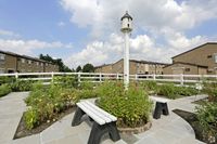 Willow Shores Palmyra Apartments community garden with flowers, benches and a bird feeder