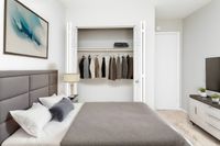 Spacious Bedroom with Queen Size Bed, Nightstands, and Full Size Dresser in an Autumn Town Center apartment.
