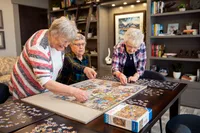 Residents Doing Puzzle in Clubhouse | Attivo Trails Waukee | Waukee, Iowa