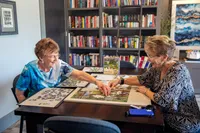 Residents Finishing Puzzle in Clubhouse | Attivo Trails Waukee | Waukee, Iowa